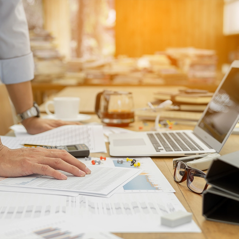 Office desk with a person reviewing documents and a laptop, illustrating content marketing strategy and creation.