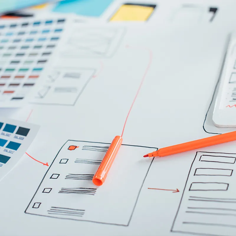 Website wireframe planning with color swatches and orange marker, concept for topical authority SEO content structure and site architecture.